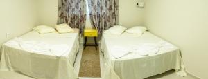 2 camas en una habitación con sábanas blancas en Nossa Casa de férias em Alter do Chão, en Alter do Chao