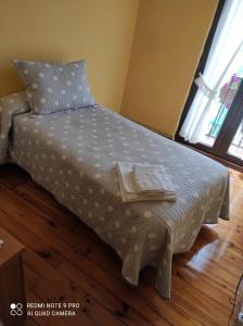 a bedroom with a bed with two towels on it at Pensión Rosa in Cabezón de la Sal