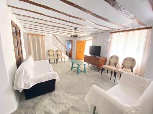een woonkamer met witte meubels en een televisie bij Alojamiento Casa Veronica in Moratalla