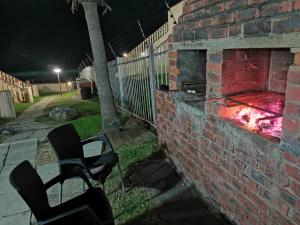 two chairs sitting in front of a brick fireplace at night at Uvongo cabanas 5A in Margate