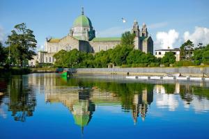 a building with a reflection in a body of water at Number 53 in Galway