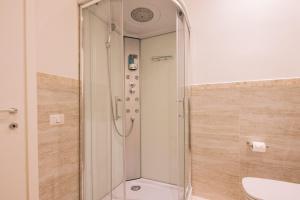 a shower with a glass door in a bathroom at La Promenade Rooms & Suites in Olbia