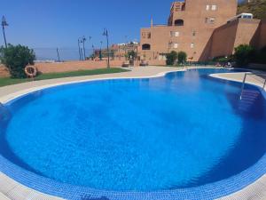 a large blue swimming pool in front of a building at Mojacar Playa para Familias in Mojácar
