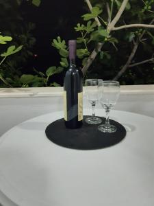 - une bouteille de vin et 2 verres à vin sur une table dans l'établissement Apartman Danilo, à Ulcinj