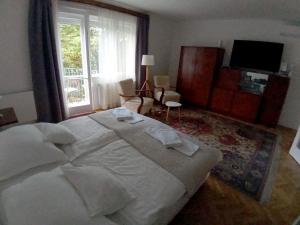 a bedroom with a large white bed and a window at Deák apartmanok in Sopron