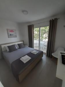 - une chambre avec un grand lit et un balcon dans l'établissement Apartman Danilo, à Ulcinj