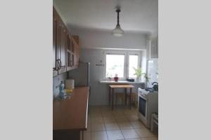 a kitchen with a refrigerator and a table at Apartament z przepięknym widokiem w samym centrum in Częstochowa