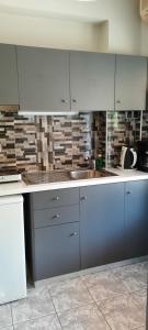 a kitchen with white cabinets and a sink at Villa Bella Vista in Marathias