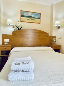 een hotelkamer met een bed met handdoeken erop bij Hostal Casa Isabel in Portonovo