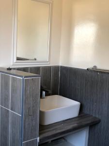uma casa de banho com um lavatório branco e um espelho. em Villa 134 Modipane em Gaborone