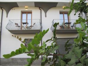 budynek z 2 balkonami z krzesłami w obiekcie Affittacamere Su Maistu e Linna w mieście Cardedu