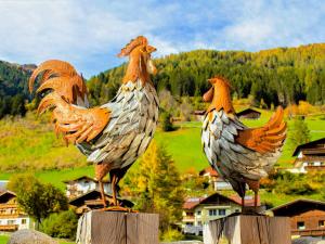 two statues of chickens sitting on posts in a village at Apartment Anna by Interhome in Neustift im Stubaital