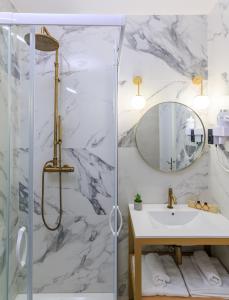 ein Bad mit einer Dusche, einem Waschbecken und einem Spiegel in der Unterkunft Hôtel Flor in Saint-Florent
