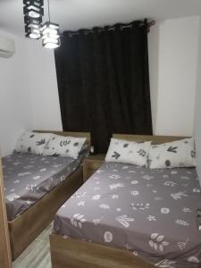 シャルム・エル・シェイクにあるOne bedroom apartment in Rivera Sharmのベッドルーム1室(ベッド2台、黒いカーテン付) +6枚の写真