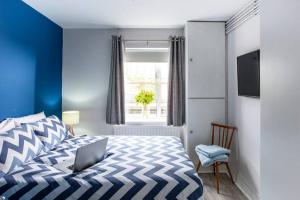 a bedroom with a bed with a laptop on it at Luxury City Apartment Underground Parking 5* in Belfast