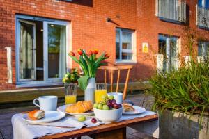 a table with plates of food and a bowl of fruit at Luxury City Apartment Underground Parking 5* in Belfast +6 photos