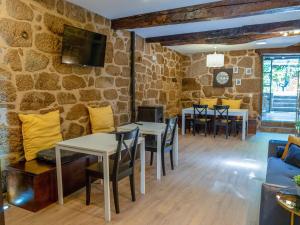 a dining room with tables and chairs and a stone wall at Douro Village in Vila Real