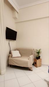a living room with a couch and a flat screen tv at Nearby the sea in Asprovalta