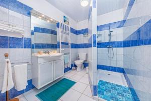 y baño azul y blanco con ducha y lavabo. en manoir de vauville, en Fresville