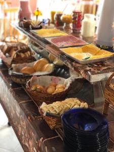 a buffet with baskets of food on a table at Pousada Fazenda da Invernada in Urubici