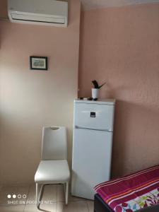 una nevera blanca y una silla en una habitación en Villa Maria, en Opatija