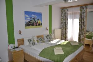 a bedroom with a large bed with green accents at Erlebnisbauernhof Urak in Sankt Kanzian