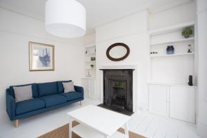 uma sala de estar com um sofá azul e uma lareira em Elegant York House - on a beach road, sleeps 12, with sea views em Worthing
