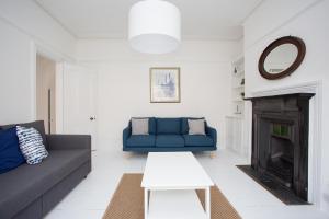 uma sala de estar com um sofá azul e uma lareira em Elegant York House - on a beach road, sleeps 12, with sea views em Worthing