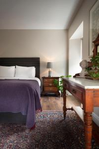 een slaapkamer met een bed en een houten bureau bij Bridge Street Townhouse in Kenmare