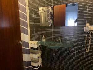 bagno con lavandino verde e specchio di Plaza Negrito Apartments a Valencia