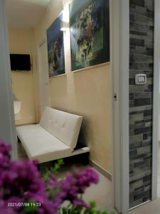 una panchina bianca in una stanza con fiori viola di Ethos - il posto da vivere a Taranto