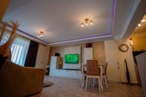 uma sala de estar com uma mesa e uma televisão em Marc Moonlight Residence em Mamaia