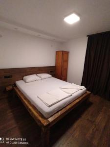シュコルピロフツにあるYanakieviのベッドルーム1室(木枠の大型ベッド1台付)