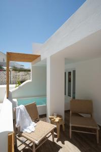 een patio met 2 stoelen en een tafel bij ALLEGRO SUITES in Oia