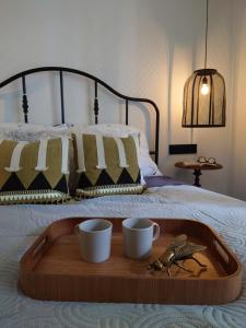 a tray on a bed with two mugs and a pair of birds at ZakoRustic in Zakopane