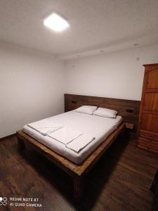 シュコルピロフツにあるYanakieviのベッドルーム1室(大型ベッド1台、木製ヘッドボード付)