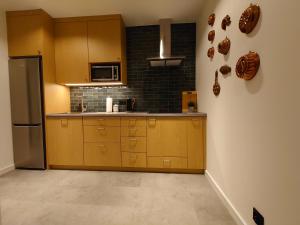 a kitchen with wooden cabinets and a stainless steel refrigerator at ZakoRustic in Zakopane