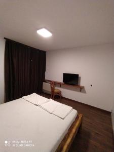 シュコルピロフツにあるYanakieviのベッドルーム1室(ベッド1台、ノートパソコン付きのデスク付)