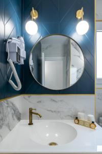 a bathroom with a sink and a mirror at Hôtel Flor in Saint-Florent