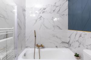 a white bathroom with a tub and a sink at Hôtel Flor in Saint-Florent