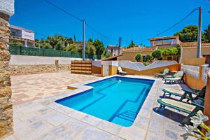 uma piscina com duas cadeiras e uma casa em Basetes - holiday home with private swimming pool in Calpe em Calpe