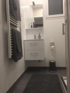 un piccolo bagno bianco con lavandino e specchio di Bel appartement au cœur de paris a Parigi