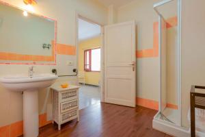 La salle de bains est pourvue d'un lavabo et d'une douche. dans l'établissement S'Apposentu Affittacamere, à Pula