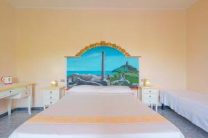 プーラにあるS'Apposentu Affittacamereのベッドルーム1室(ベッド2台付)が備わります。壁には絵画が飾られています。