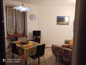 uma sala de estar com uma mesa e um sofá em La casa di Nonna Lia em Dimaro
