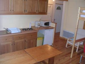 eine Küche mit Holzschränken und einer weißen Mikrowelle in der Unterkunft Résidence Gavarnie in Gèdre