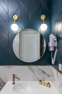 a bathroom with a mirror and a sink at Hôtel Flor in Saint-Florent