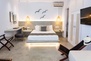 a bedroom with a bed and a desk and a tv at Likio Studios in Batsi