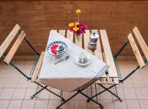 un tavolo bianco con sedie e una ciotola di fiori di Burò il Viaggiatore a Parma