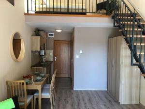 a kitchen and dining room with a table and a staircase at Castellum Apartmanház in Gyula +41 photos